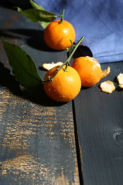 Juicy ripe tangerines with leaves on wooden table — Stock Photo, Image