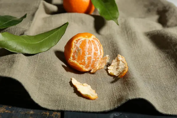 Juicy ripe tangerine with leaves on tablecloth — Stock Photo, Image