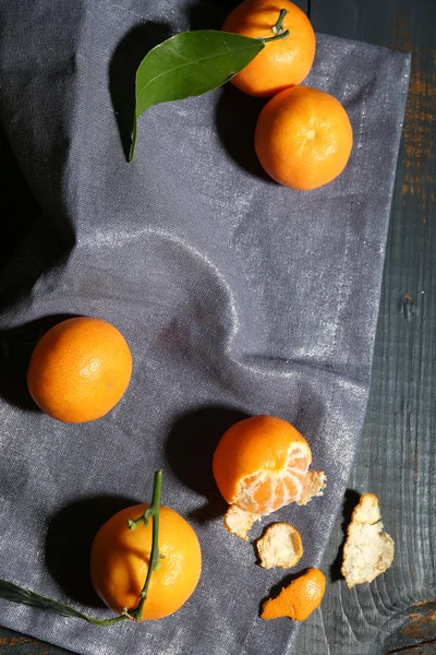 Tangerinas maduras suculentas com folhas na toalha de mesa — Fotografia de Stock