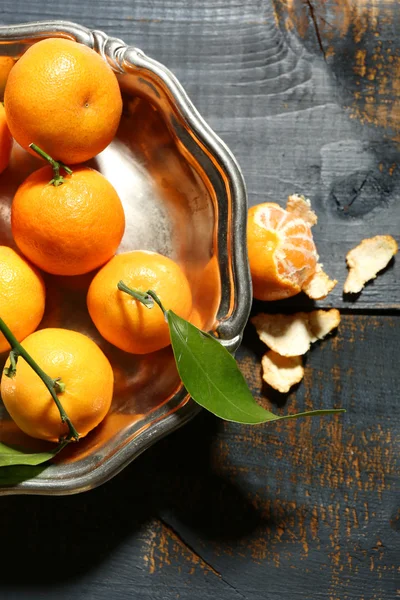 Juicy ripe tangerines with leaves on wooden table — Stock Photo, Image