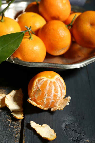 Сочные мандарины с листьями на деревянном столе — стоковое фото