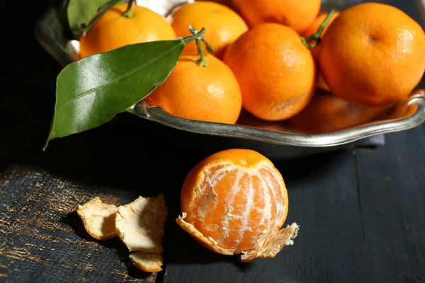 Juicy ripe tangerines with leaves on wooden table — Stock Photo, Image