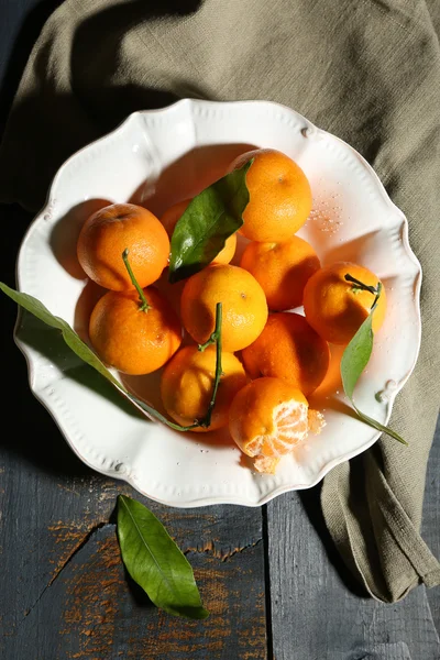 Tangerinas maduras suculentas com folhas na mesa de madeira — Fotografia de Stock