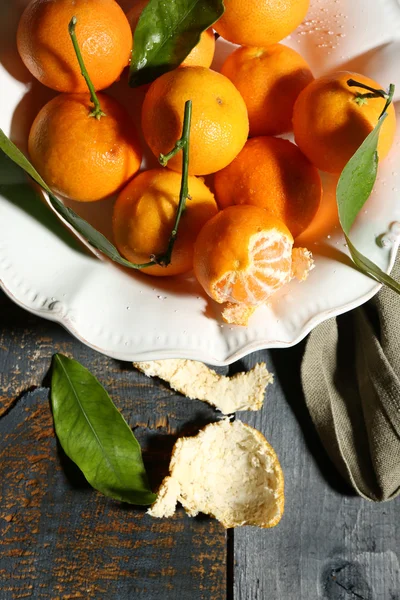 Tangerinas maduras suculentas com folhas na mesa de madeira — Fotografia de Stock