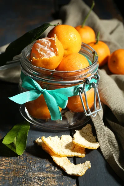 Soczyste dojrzałe mandarynki z liśćmi na drewnianym stole — Zdjęcie stockowe