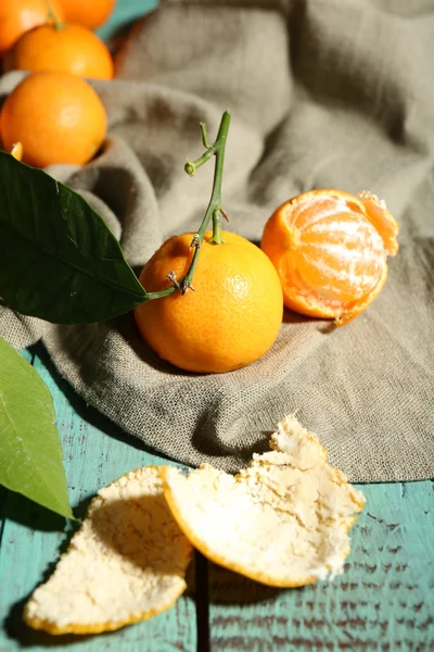 Šťavnaté zralé mandarinky s listy na dřevěném stole — Stock fotografie