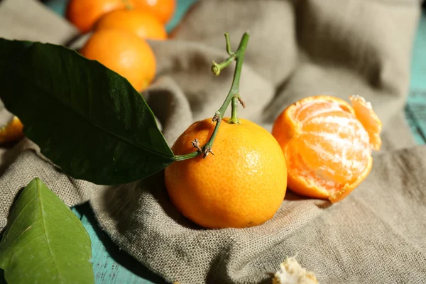 Juicy ripe tangerines with leaves on tablecloth — Stock Photo, Image