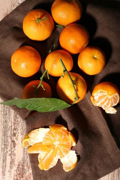 Jugosas mandarinas maduras con hojas sobre mesa de madera —  Fotos de Stock