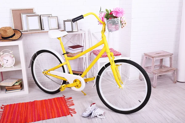 Vélo rétro jaune dans une chambre lumineuse spacieuse — Photo