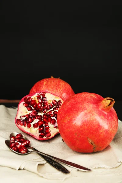 Šťavnatá zralá granátová jablka na tmavém pozadí — Stock fotografie