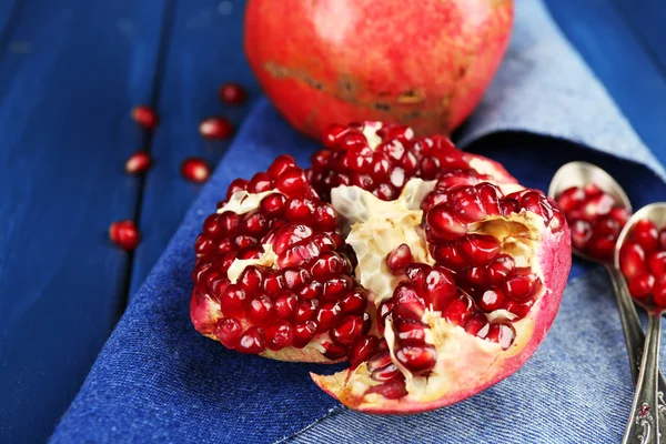 Juicy ripe pomegranates on wooden table — Stock Photo, Image