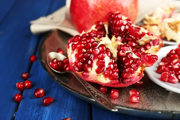 Juicy ripe pomegranates on wooden table — Stock Photo, Image