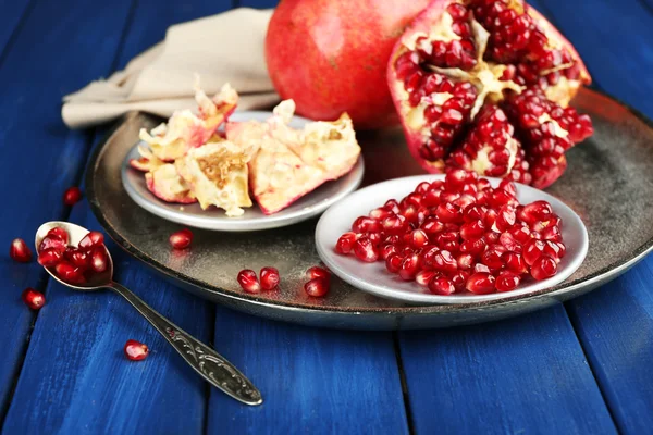 Juicy ripe pomegranates on wooden table — Stock Photo, Image