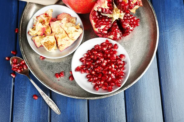 Juicy ripe pomegranates on wooden table — Stock Photo, Image