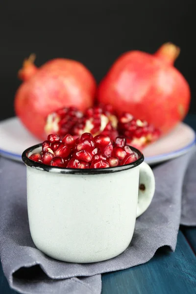 Saftiga mogen granatäpple på träbord, på mörk bakgrund — Stockfoto