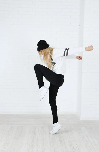 Танцовщица хип-хопа танцует на фоне стен — стоковое фото