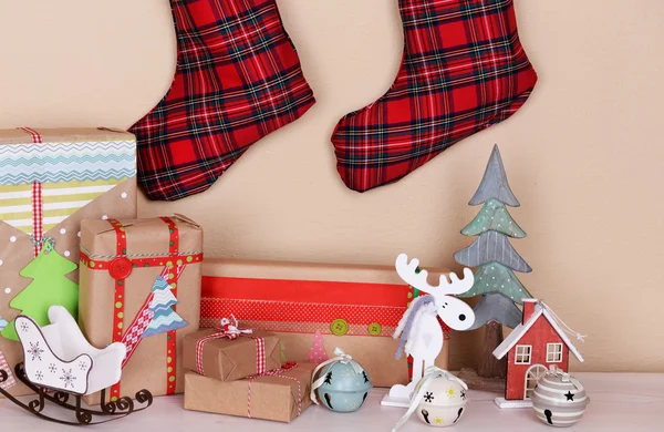 Hand-made Christmas gifts and decorations on fireplace in room — Stock Photo, Image