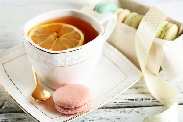 Színes macaroons csésze tea, színes fából készült háttér — Stock Fotó