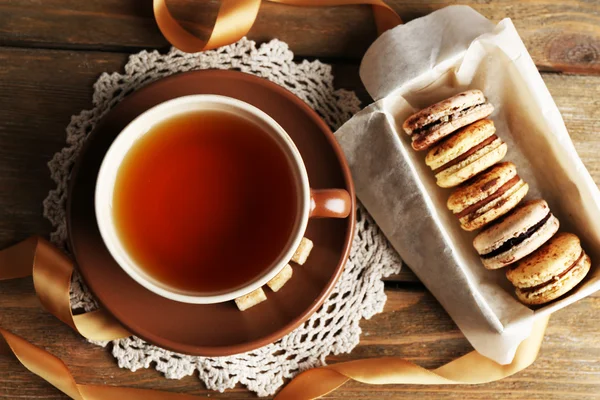 木製の背景上にお茶とカラフルなマカロン — ストック写真