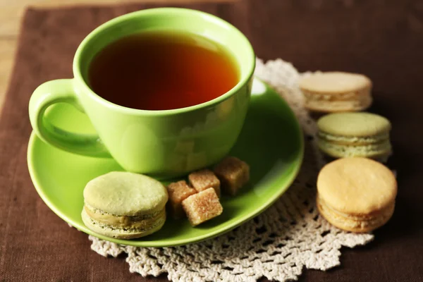 Cup of tea with colorful macarons on wooden background — Stock Photo, Image