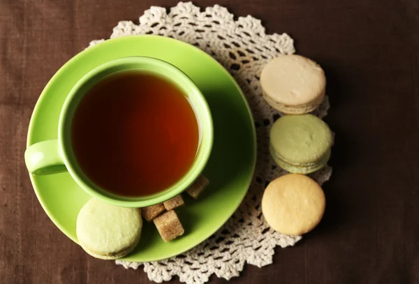 Kopje thee met kleurrijke macarons op houten achtergrond — Stockfoto