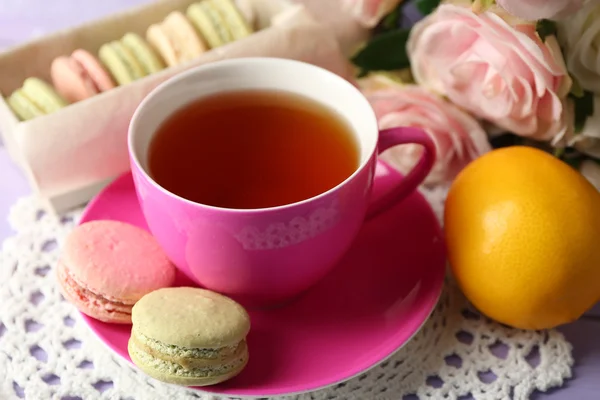 Macarrones coloridos con taza de té sobre fondo de madera —  Fotos de Stock