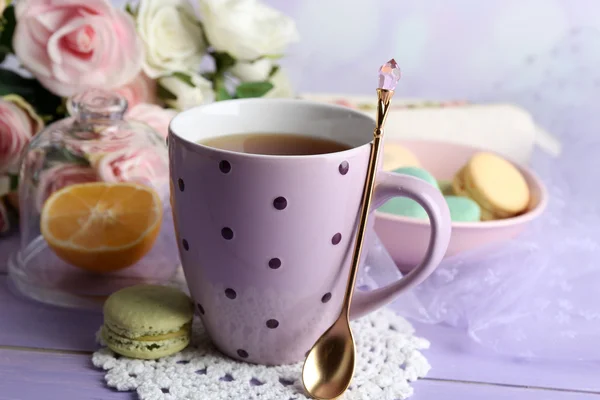 Färgglada macaroons med kopp te på trä bakgrund — Stockfoto