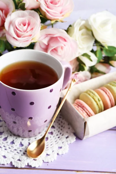 Macarrones coloridos con taza de té sobre fondo de madera — Foto de Stock