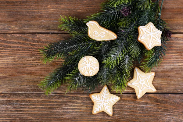 Galletas de jengibre con decoración navideña sobre fondo de mesa de madera —  Fotos de Stock