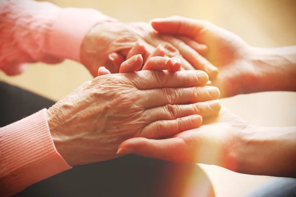 Vecchi e giovani che si tengono per mano — Foto Stock