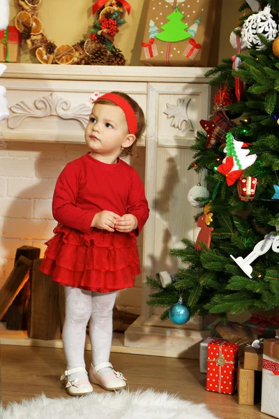 Menina perto de lareira e árvore de Natal — Fotografia de Stock