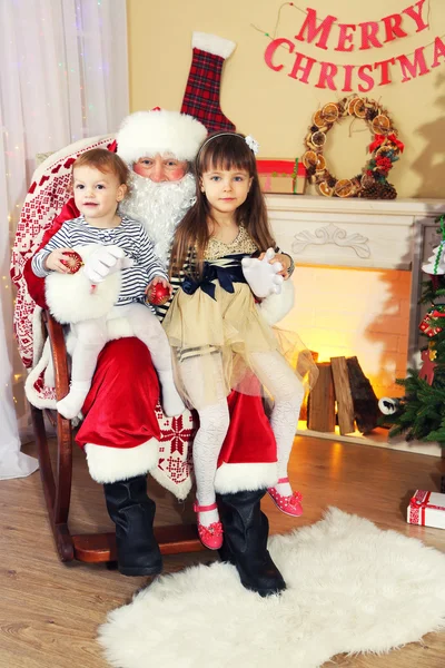 Santa Claus with two little cute girls near  fireplace and Christmas tree at home — Stock Photo, Image