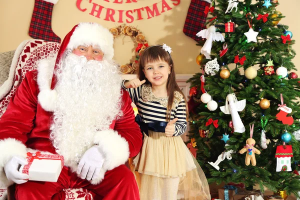 Santa Claus geven aanwezig om te slapen beetje schattig meisje kerstboom thuis — Stockfoto