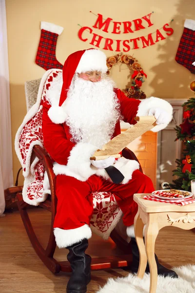 Santa Claus sentado con la lista de regalos —  Fotos de Stock