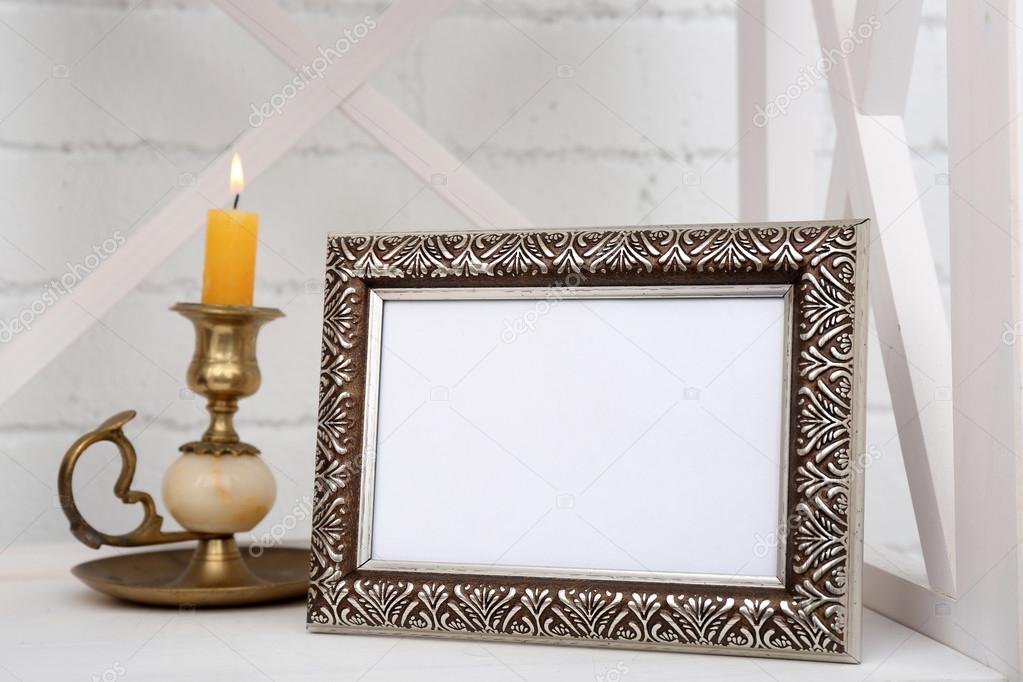 Photo frame on shelf with candlestick