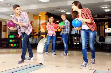 bowling salonu içinde oynayan genç arkadaşlar