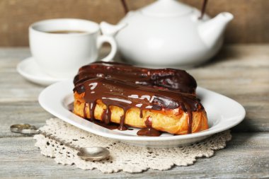 Lezzetli eklerleri ve ahşap masa üzerinde çay