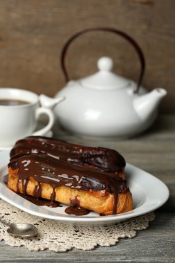 Lezzetli eklerleri ve ahşap masa üzerinde çay