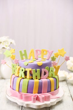 Lezzetli doğum günü pastası ışık arka plan üzerinde masada