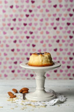 Renk arka plan üzerinde ahşap masa üzerinde lezzetli peynirli kek