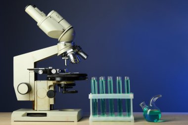 Mikroskop ve masaya renk arka plan üzerinde test tüpleri