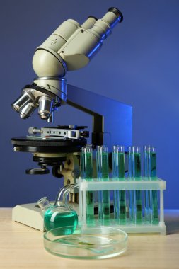 Mikroskop ve masaya renk arka plan üzerinde test tüpleri