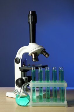 Mikroskop ve masaya renk arka plan üzerinde test tüpleri