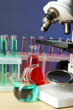 Mikroskop ve masaya renk arka plan üzerinde test tüpleri