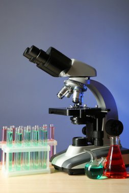 Mikroskop ve masaya renk arka plan üzerinde test tüpleri