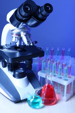 Mikroskop ve masaya renk arka plan üzerinde test tüpleri