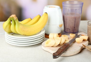 Parlak zemin üzerine ahşap masa üzerinde kesme tahtası üzerinde muz dilimlenmiş