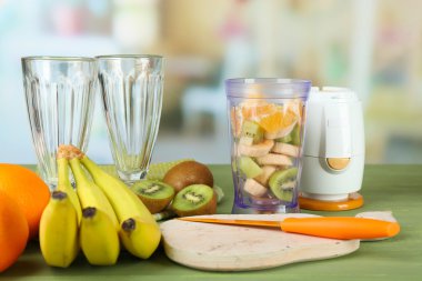 Dilimlenmiş meyve ve blender parlak zemin üzerine ahşap tablo