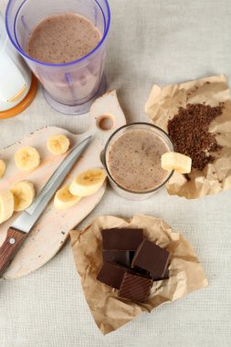 Ahşap arka plan üzerinde muz kesme tahtası ve kıyılmış çikolata, dilimlenmiş