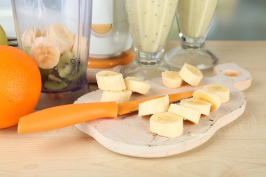 Dilimlenmiş meyve ve blender parlak zemin üzerine ahşap tablo